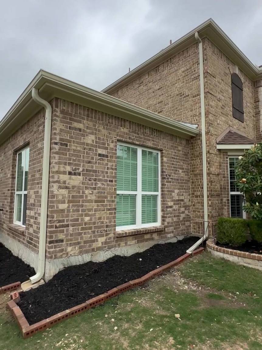 The finished brick addition beside the two-story home, with new windows, gutters and landscaping